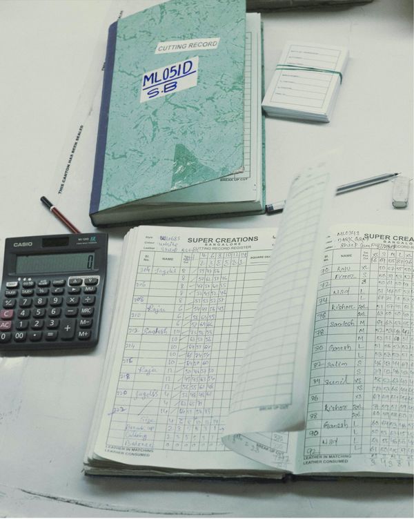 Close up on a quality check form with a notepad and a calculator.