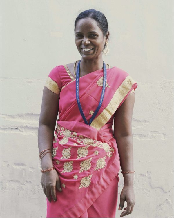 An smiling Indian woman is facing the camera.
