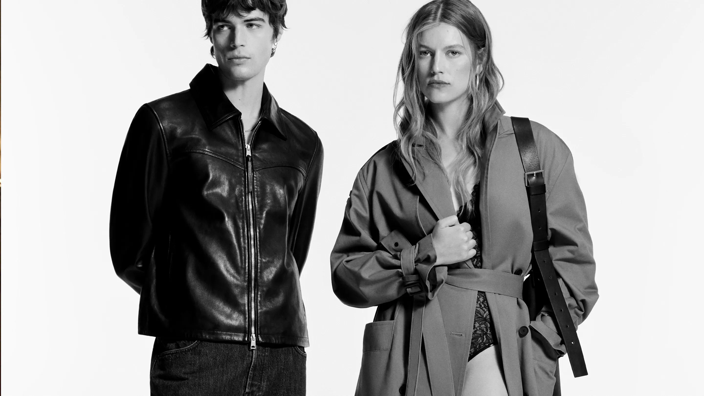 A male and female and male model sitting in the back of a car wearing black clothing.