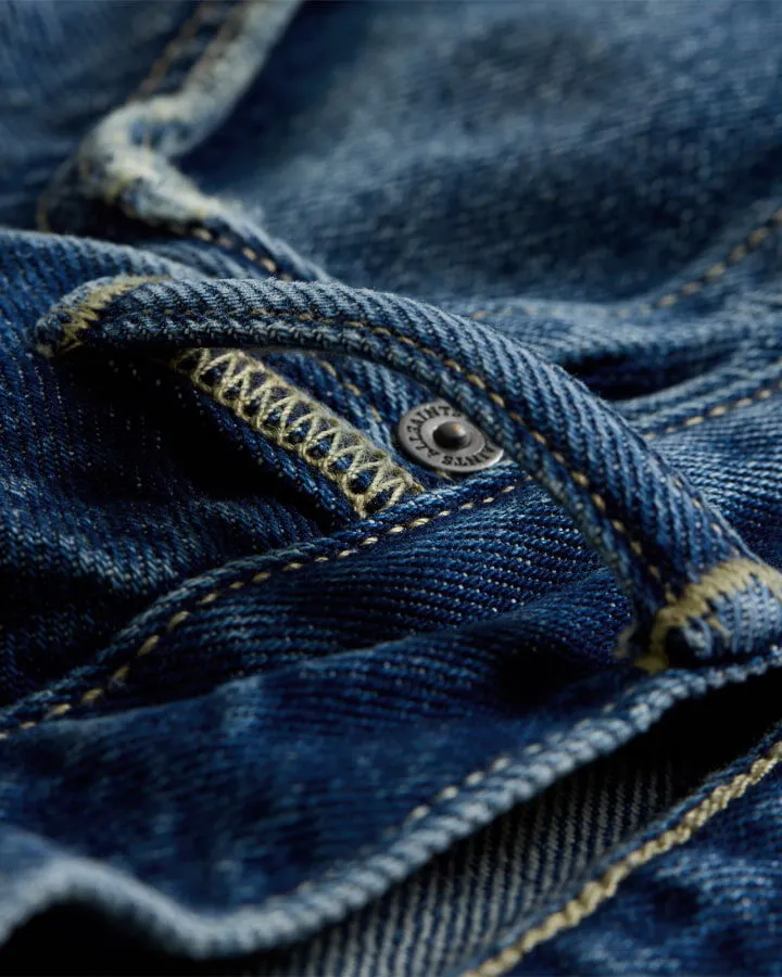 Closeup on a denim belt loop.