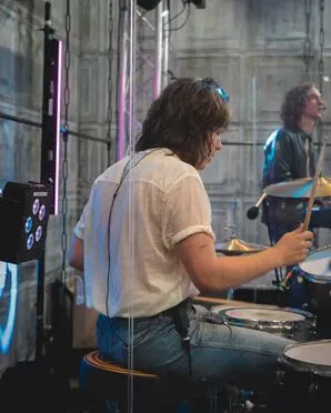 The Sukis band member playing the guitar and singing in the microphone