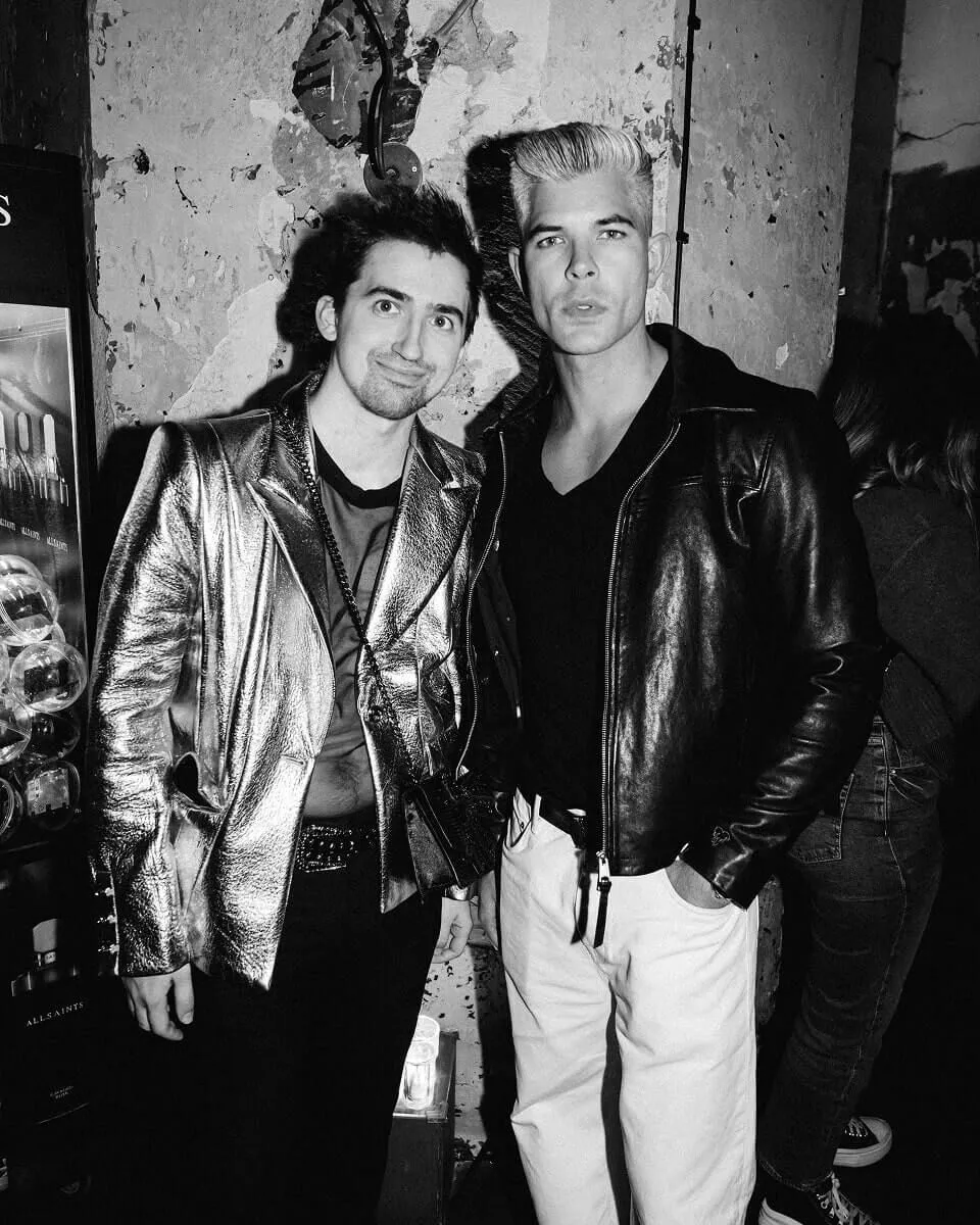 Black and white photograph showing two men wearing leather jacket