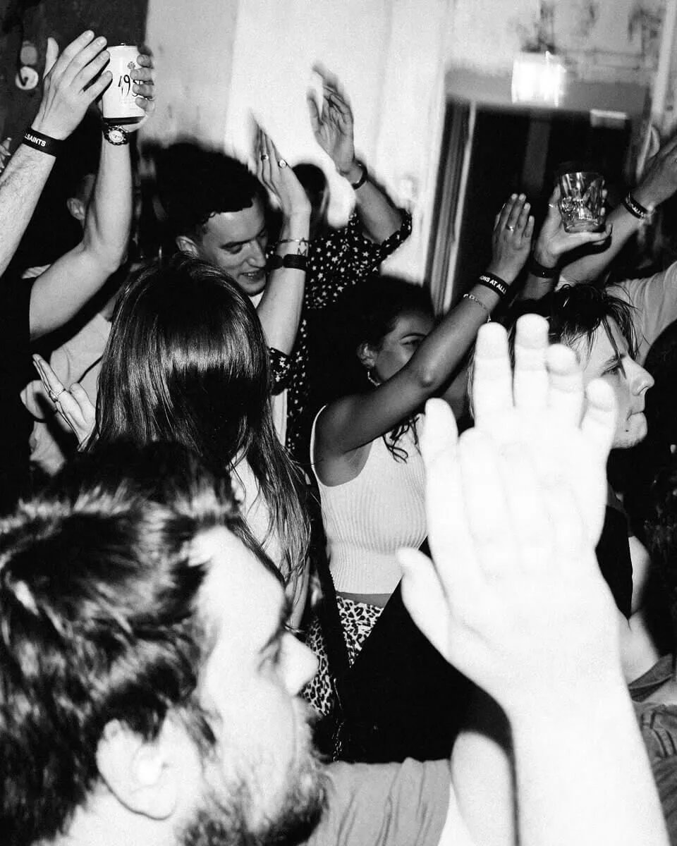 Black and white photograph showing the audience dancing and clapping