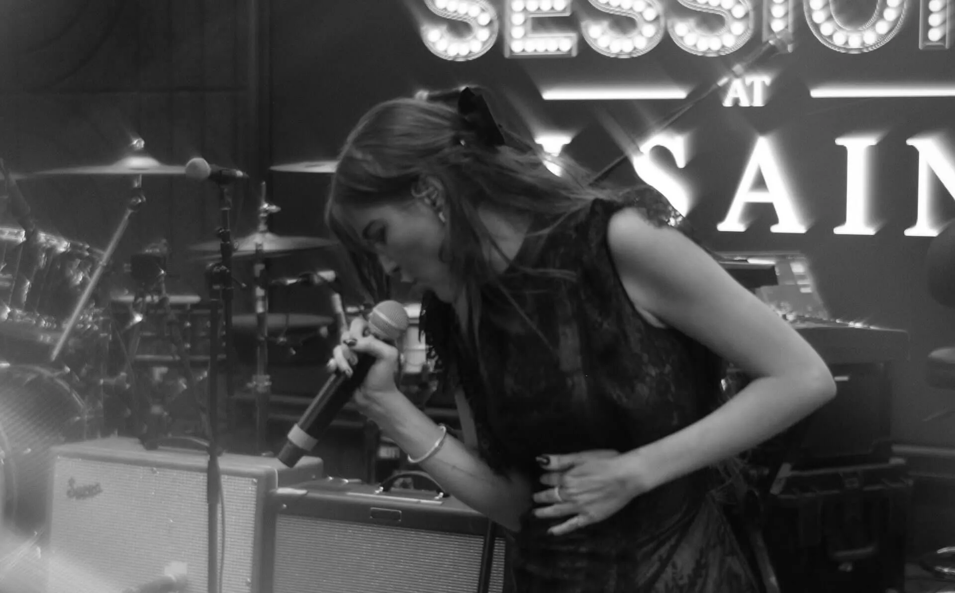 Black and white photo Greylin James Rue singing into microphone