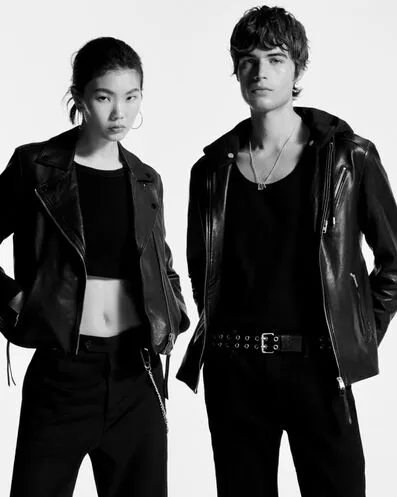 Man and woman wearing black leather jacket & black studded leather vest.