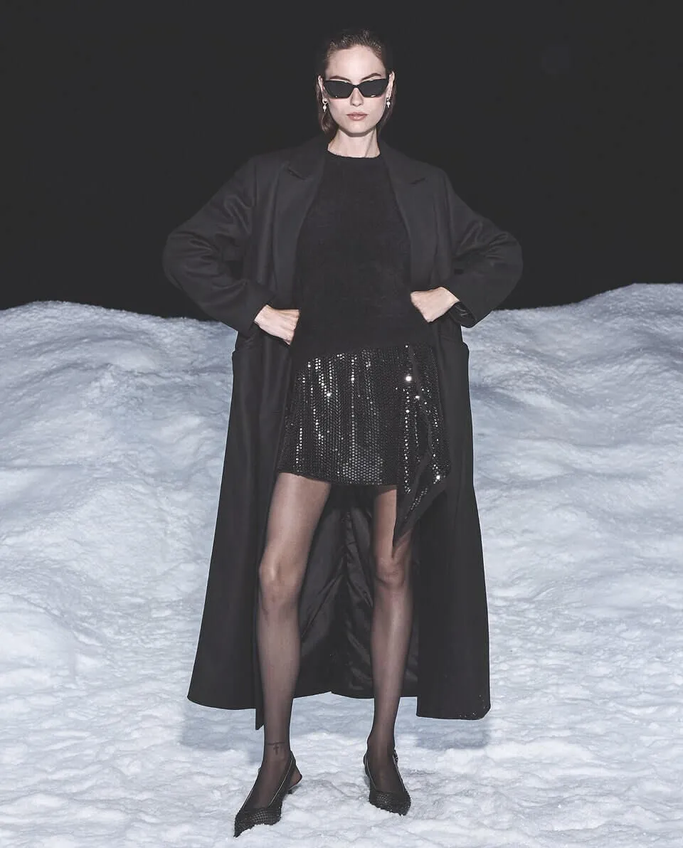 Women wearing black trench stood on a background of snow