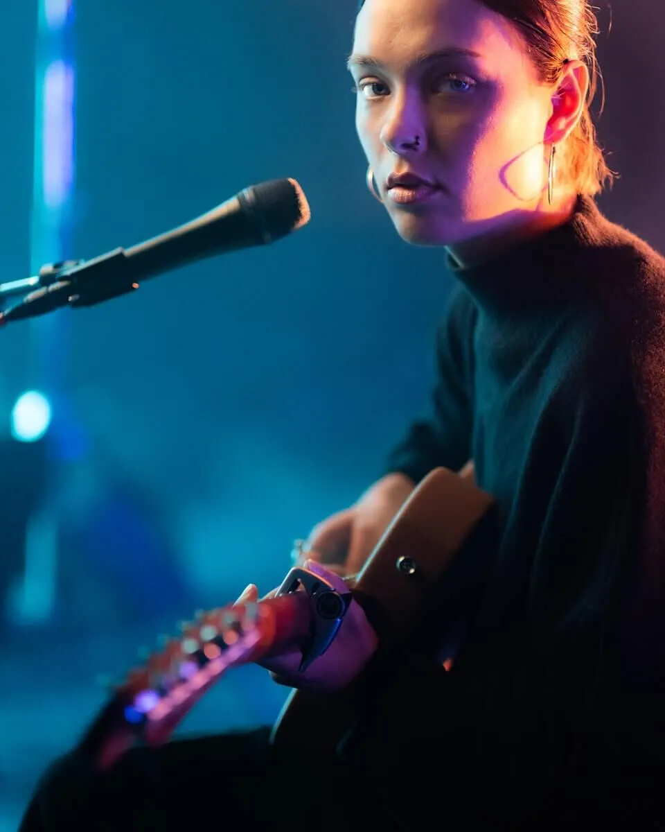  Profile portrait of Abby sitting on stage infron of the microphone.