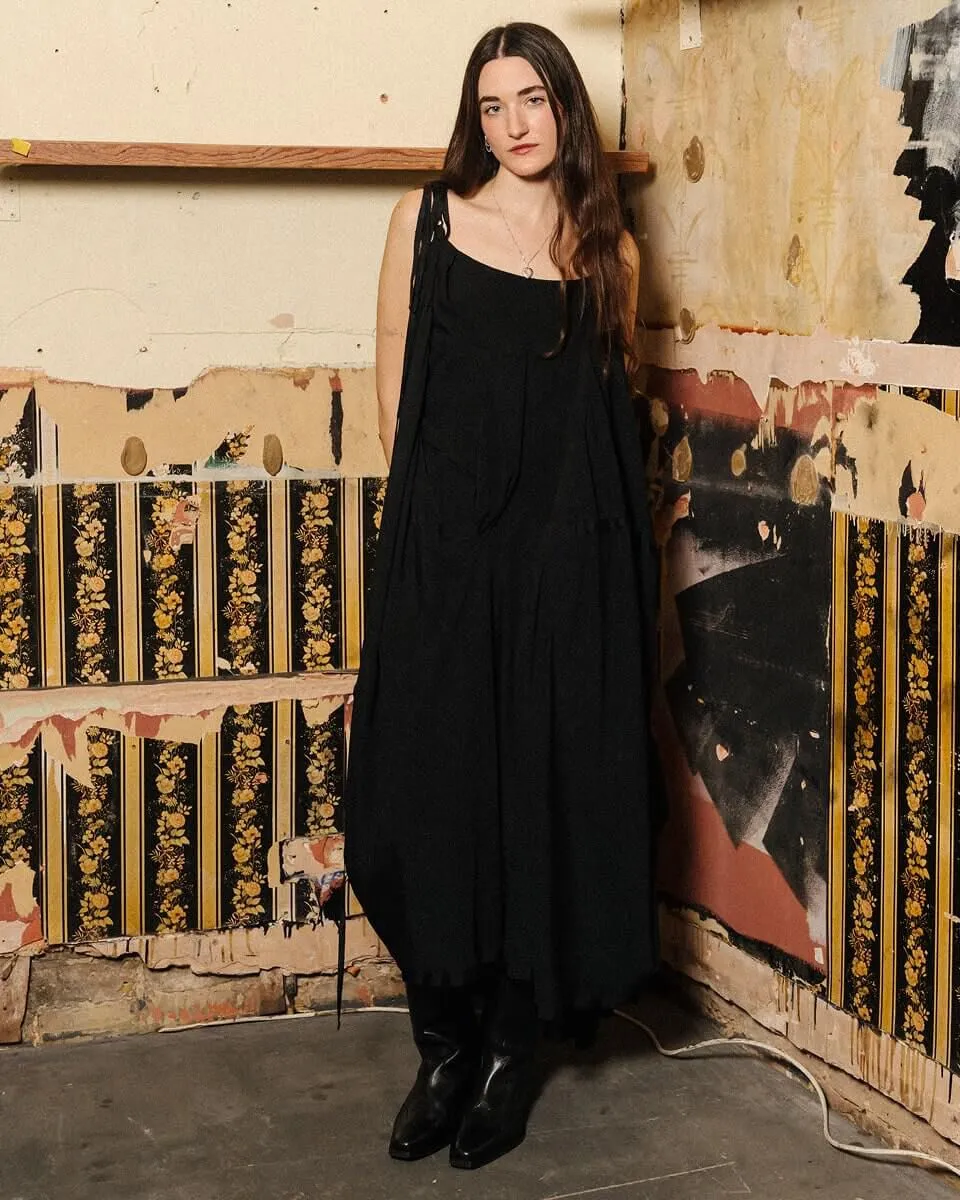 Fulllength shot of Etta Marcus posing infront of a wall with partially ripped off wallpaper.