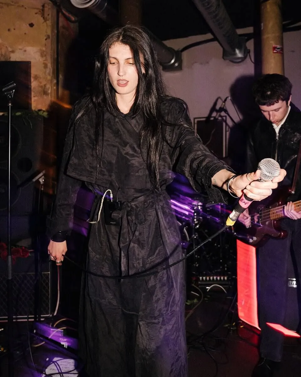 Candid shot of Lucia & The Best Boys front singer being led of stage.