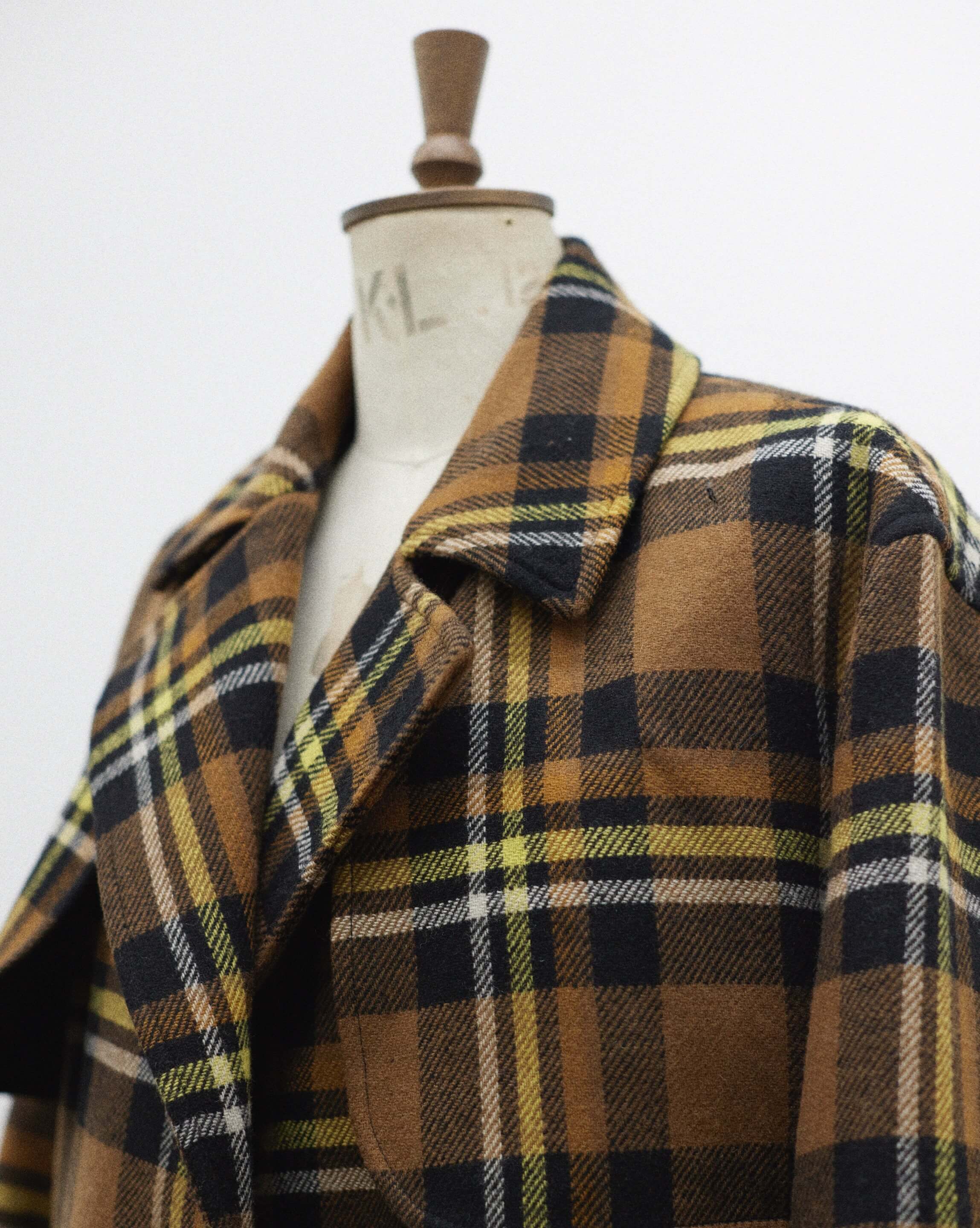 Checked coat on a sewing mannequin.