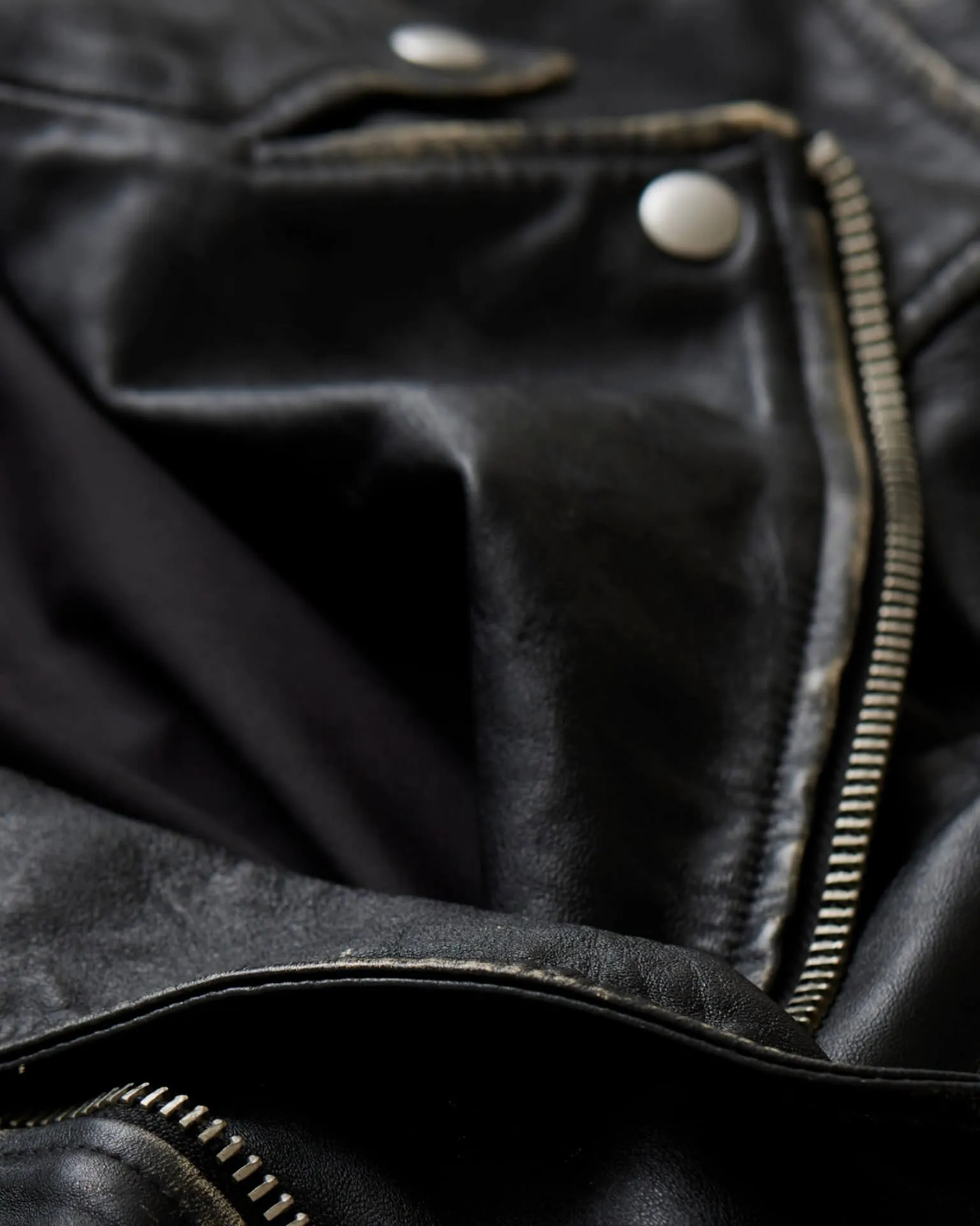 Closeup photograph of a black leather jacket.