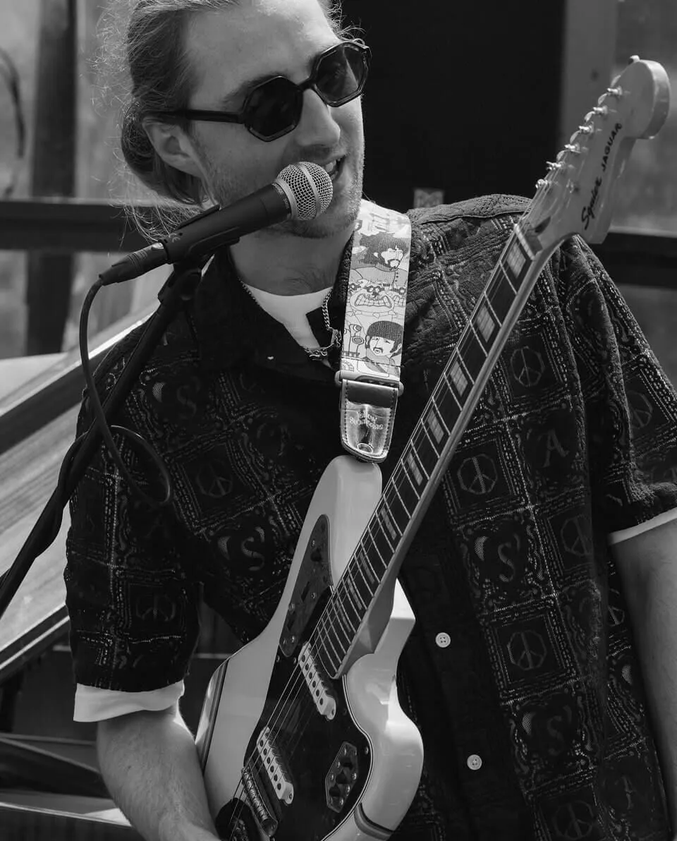 A black and white shot of the frontsigner with guitar.