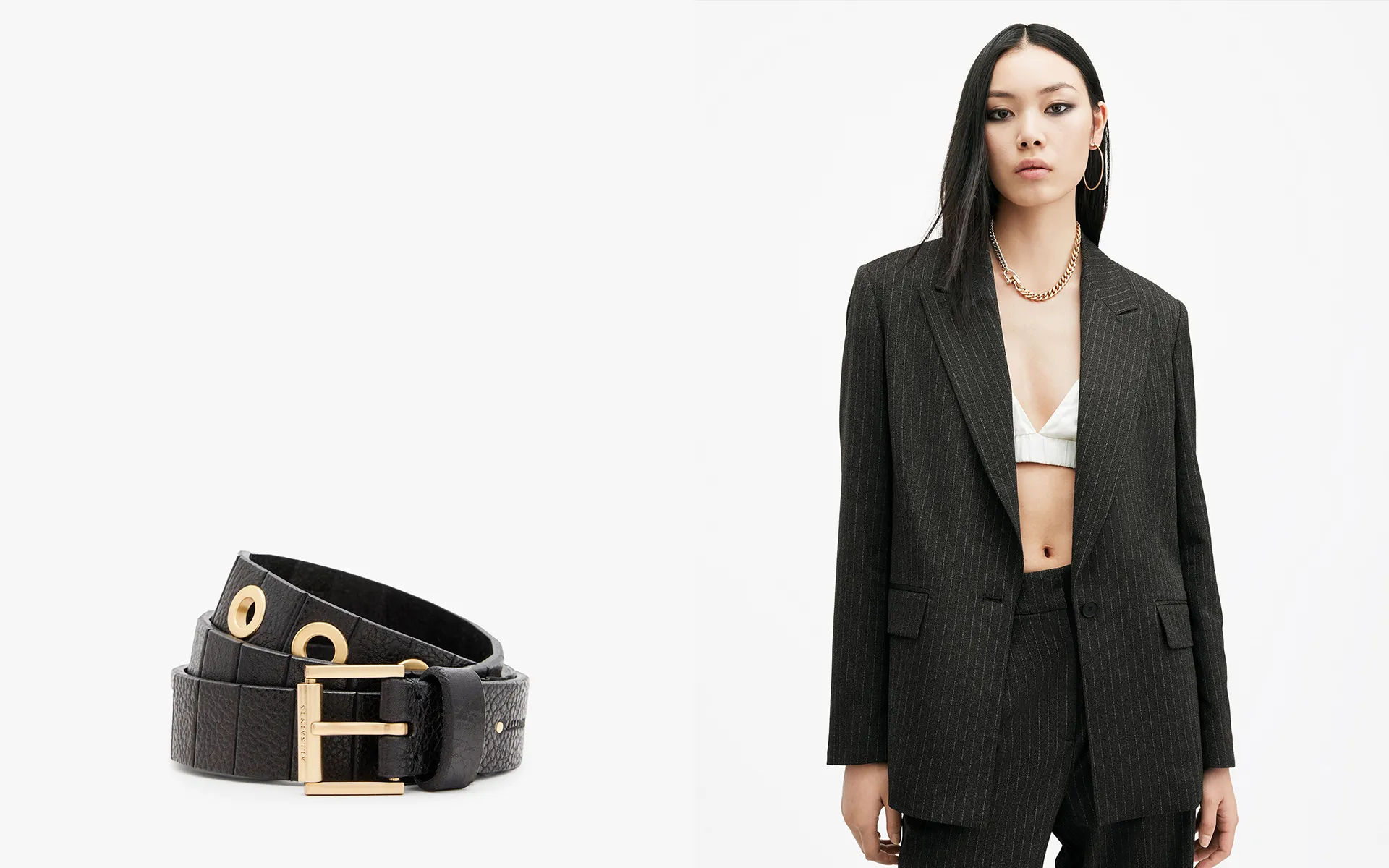 Collage showing a black leather belt on the left side and a model wearing a black blazer with contrasting white piping on the right side.