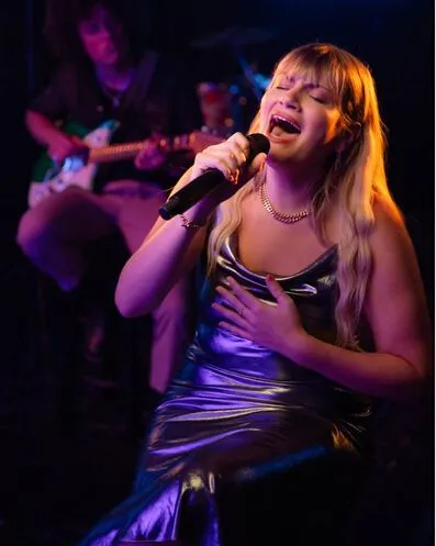 Singer Maddie Zahm singing into a microphone.