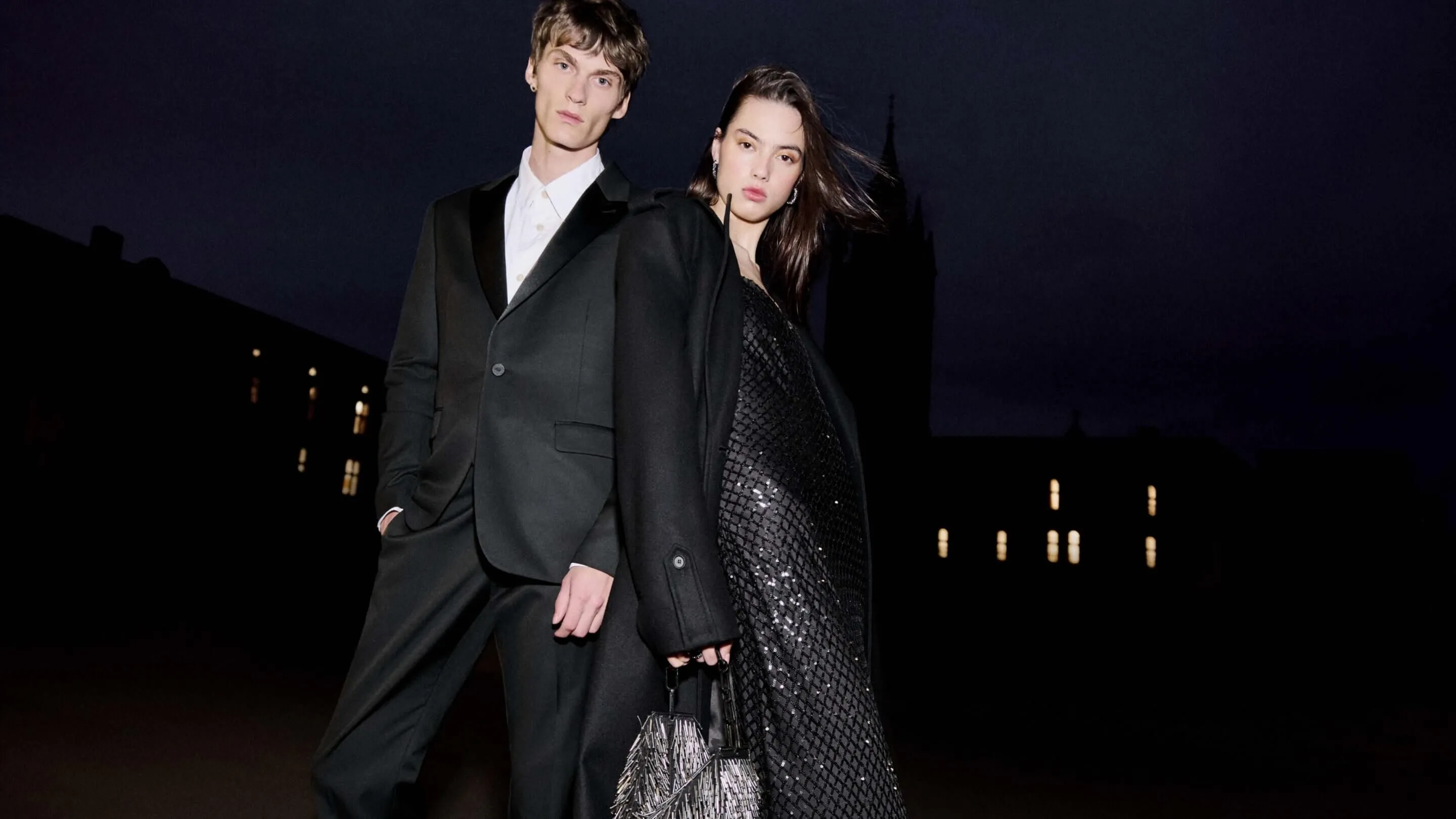 A male and female and male model sitting in the back of a car wearing black clothing.