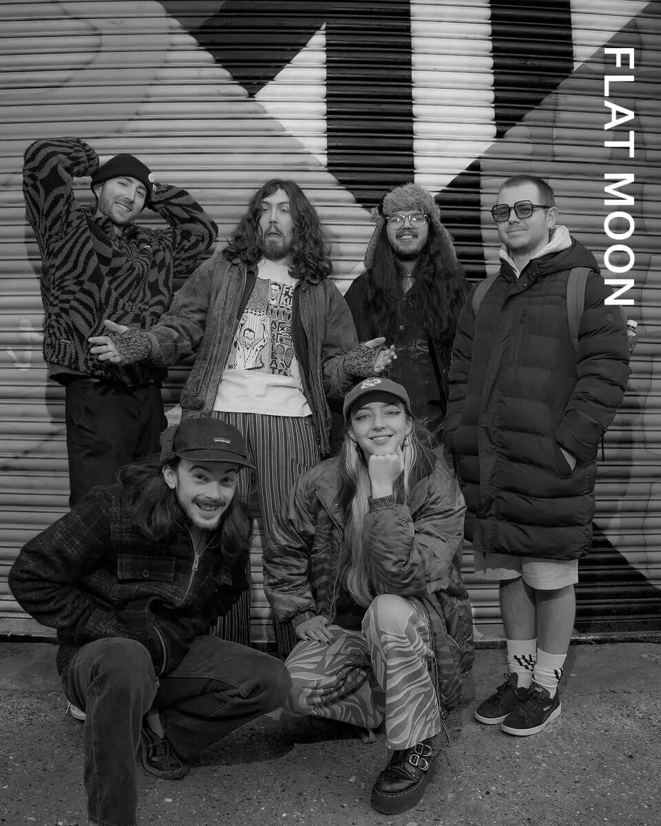 Full length shot of FLAT MOON posing infront of a wall.