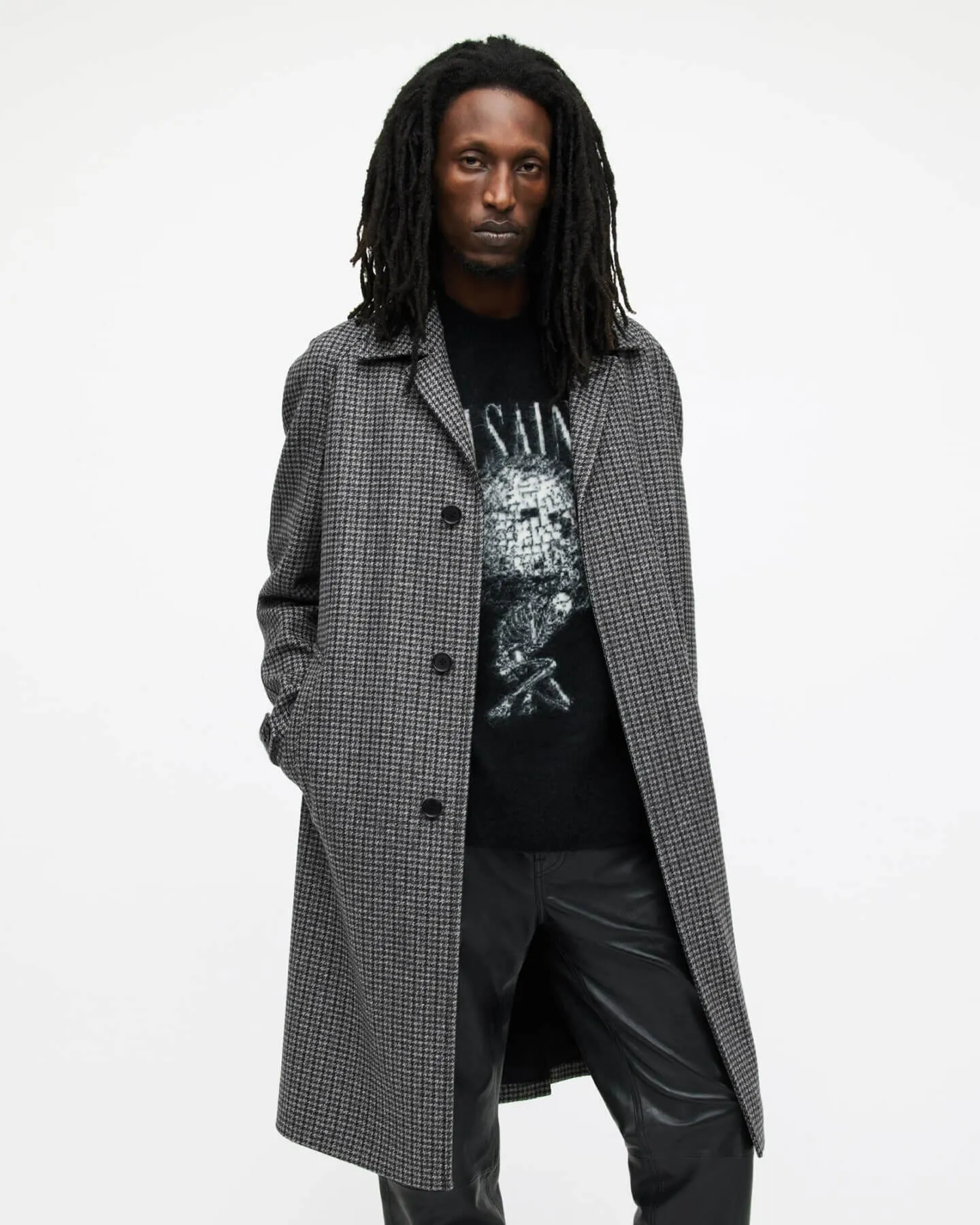 Man wearing a check coat and leather trousers.