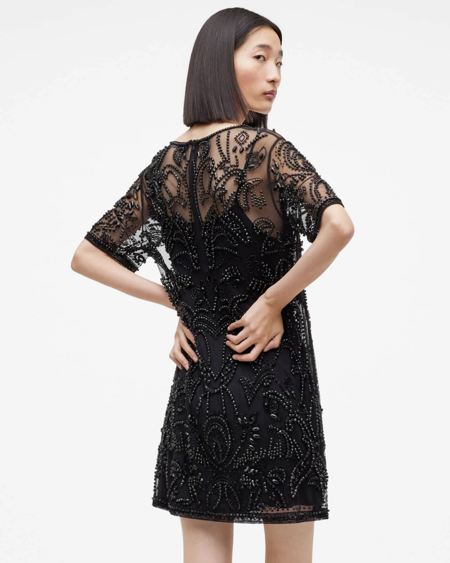 Woman wearing a black pearl embroidered dress.