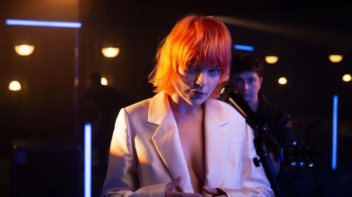 Closeup of Donna Missal standing on stage wearing a white blazer.