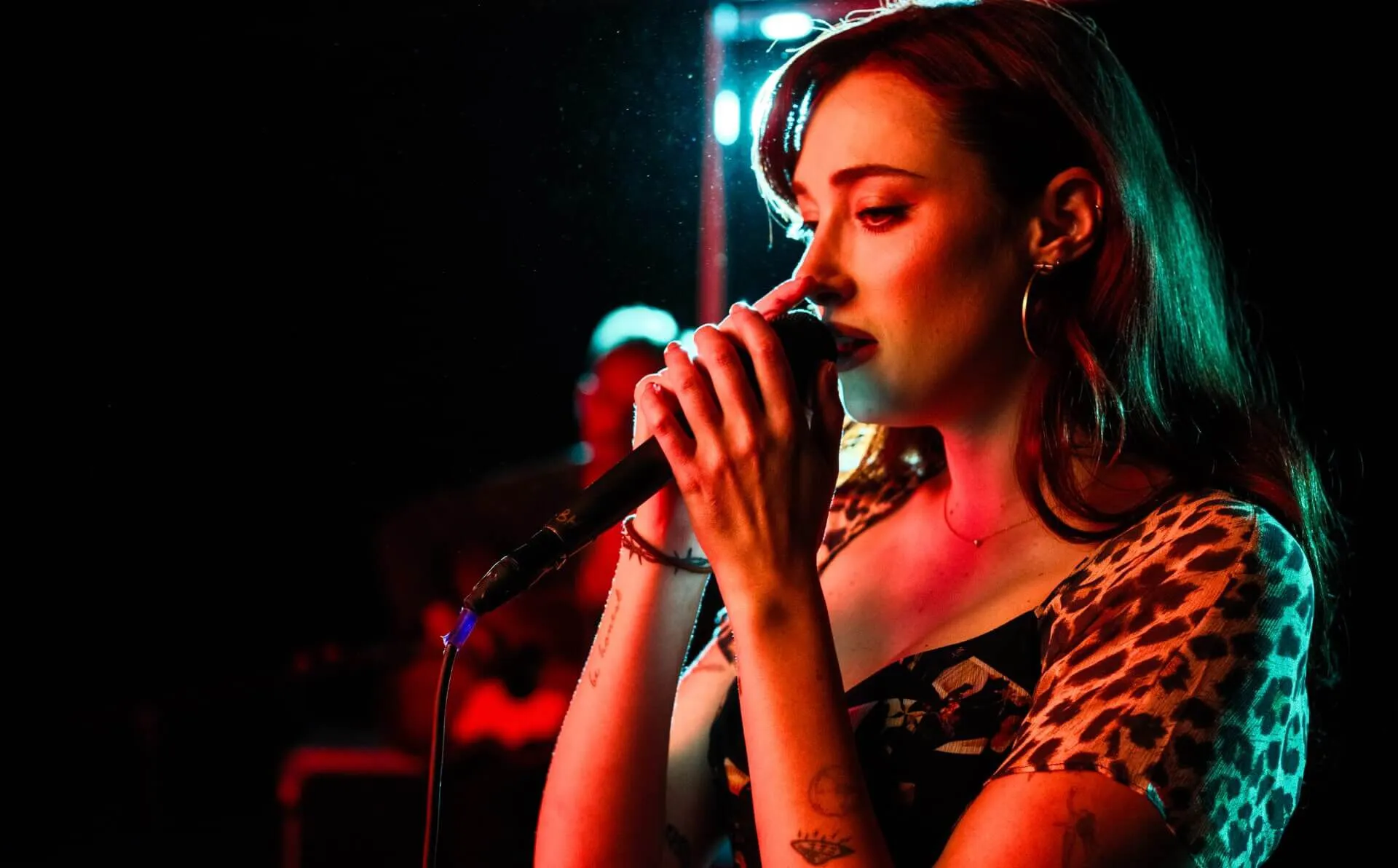 Olivia OBrien singing in the microphone.